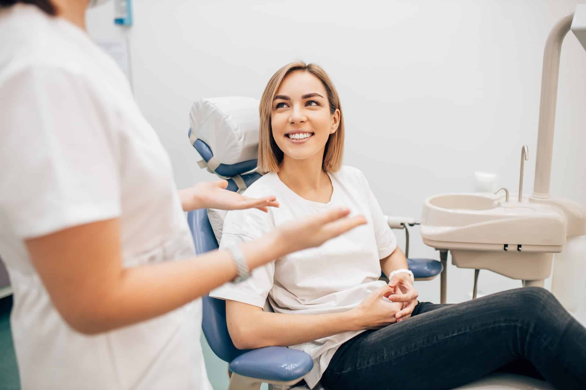 Patient sitting in dentist office talking with the dentist.